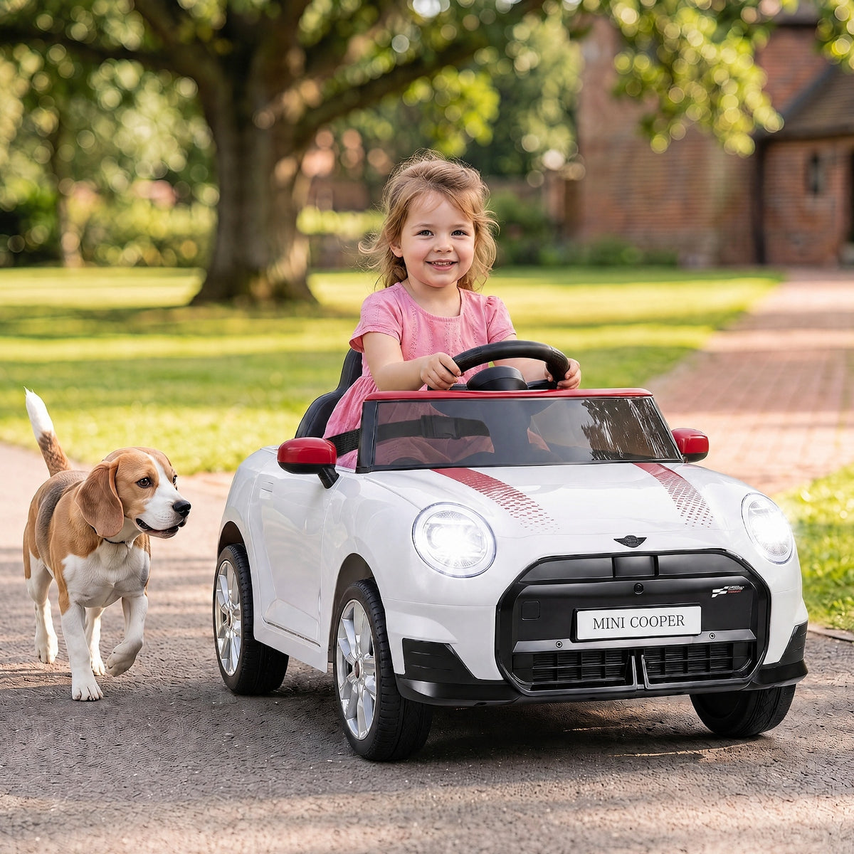 Vaikas važiuoja baltu Mini Cooper stiliaus elektriniu automobiliu lauke
